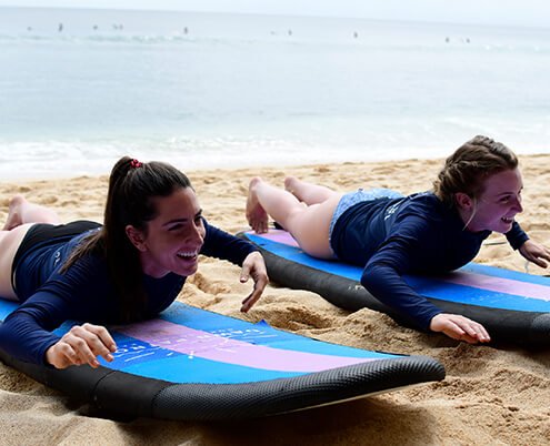 Beginner surfers on soft top foam boards